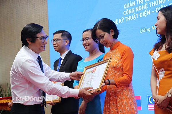 Phó chủ tịch UBND tỉnh Nguyễn Sơn Hùng trao Giấy khen của Trường đại học Lạc Hồng cho các cá nhân có nhiều đóng góp trong công tác kiểm định chất lượng. Ảnh: Hải Yến