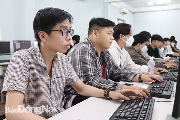Em Nguyễn Chí Thành (bìa trái), sinh viên năm thứ 3, Khoa Công nghệ thông tin Trường đại học Lạc Hồng đã được nhận học bổng dành cho học sinh, sinh viên khuyết tật từ năm học lớp 10. Phần học bổng này san sẻ bớt “gánh nặng” học phí cho em