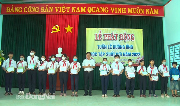Ông Bồ Văn Bảo, Bí thư, chủ tịch UBND xã Nhân Nghĩa trao học bổng cho các em học sinh nghèo hiếu học. Ảnh: Đinh Tài
