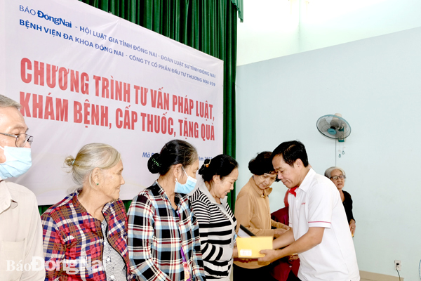 Phó tổng biên tập Báo Đồng Nai Đinh Kim Tuấn tặng quà cho người nghèo, có hoàn cảnh khó khăn ở xã Mã Đà. Ảnh: Đ.Tùng