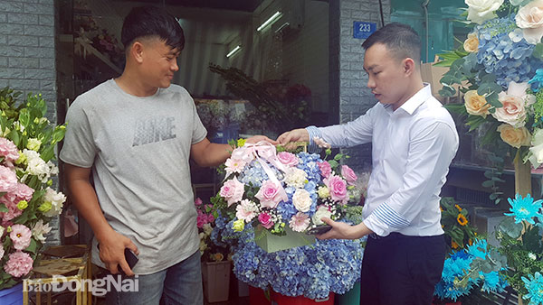 Khách hàng tham khảo, chọn mua các loại giỏ hoa tươi tại một cửa hàng hoa trên đường 30-4 (TP.Biên Hòa) nhân dịp 20-11. Ảnh: Hải Hà