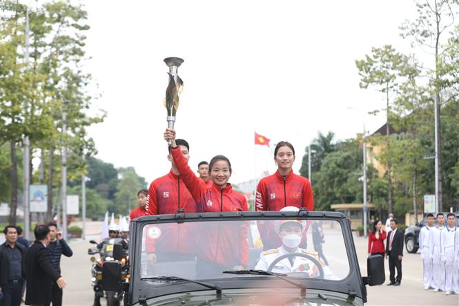 VĐV điền kinh Nguyễn Thị Oanh cùng đoàn VĐV tiêu biểu thực hiện nghi thức rước đuốc từ Bảo tàng Hồ Chí Minh. Ảnh: Minh Quyết - TTXVN