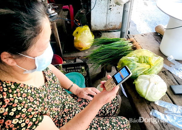 Điện thoại thông minh rất cần thiết cho mọi người dân trong xu hướng phát triển công nghệ số. Trong ảnh: Một phụ nữ buôn bán nhỏ ở chợ Cổng 2 (thuộc P.Trung Dũng, TP.Biên Hòa) vẫn chưa có điều kiện trang bị điện thoại thông minh. Ảnh minh họa: P.Liễu