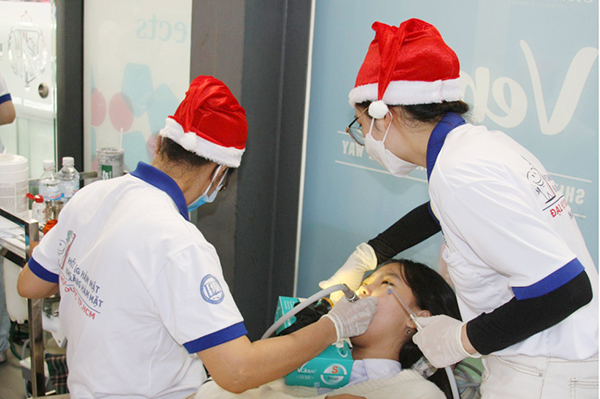 Một em nhỏ được các bác sĩ nha khoa giúp khám răng