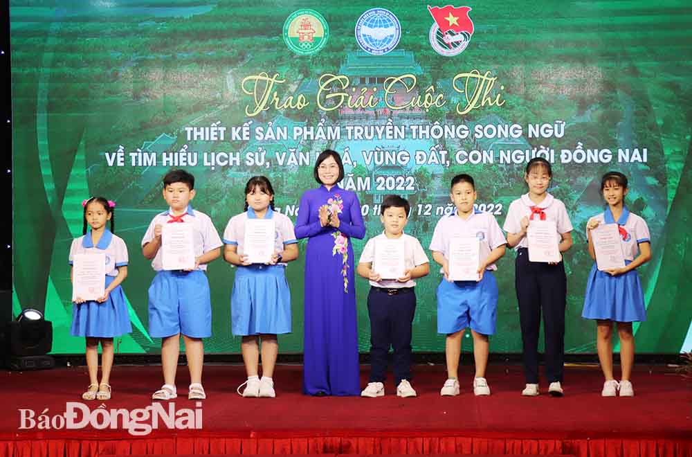 Phó chủ tịch UBND tỉnh Nguyễn Thị Hoàng trao giải cho các tác giả đạt giải của bảng B (dành cho học sinh tiểu học, THCS) cuộc thi Thiết kế sản phẩm truyền thông song ngữ về tìm hiểu lịch sử, văn hóa, vùng đất con người Đồng Nai năm 2022.