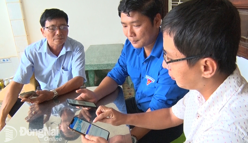 Công chức TP.Long Khánh hướng dẫn người dân cài đặt ứng dụng Long Khanh Smart để kết nối chính quyền và người dân bằng hình thức trực tuyến. Ảnh: C.NGHĨA