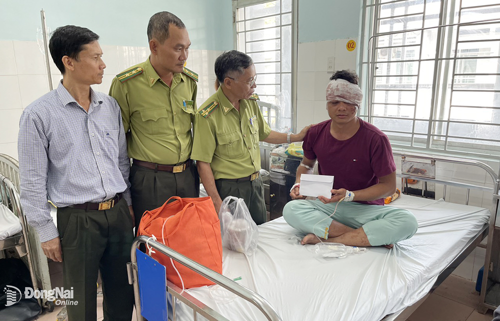 Phó chi cục trưởng Chi cục Kiểm lâm Đồng Nai Lê Việt Dũng (thứ 2 từ phải sang) cùng đoàn đến thăm hỏi, động viên kiểm lâm viên bị “lâm tặc” đánh gây thương tích vào ngày 2-3-2023