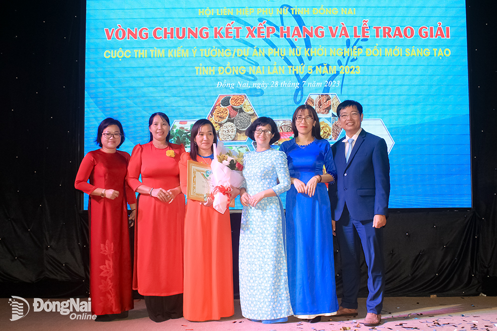 Các đại biểu chụp hình lưu niệm với thí sinh Hoàng Thị Mỹ Nhung, tác giả của dự án Sản xuất và kinh doanh sản phẩm từ da cá sấu